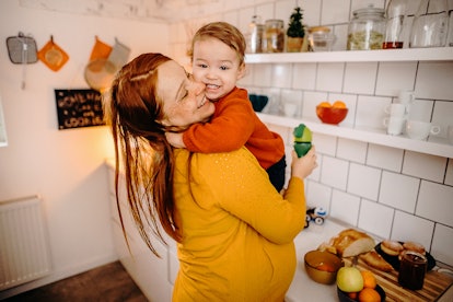 Pregnant mother and son exchange tenderness in the kitchen