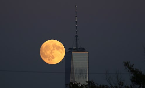 The moon rises behind One World Trade Center at sunset in New York City on October 4, 2017, as seen ...