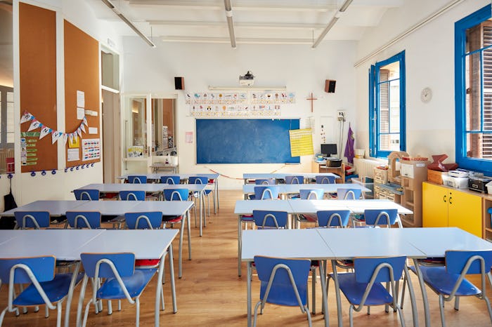 View from back row of learning environment for Spanish-speaking students with blue chalkboard, hardw...