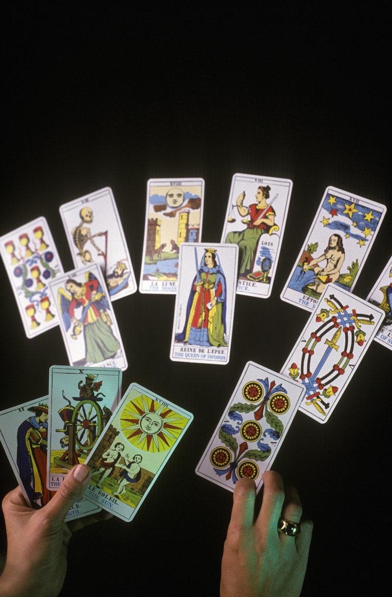 A woman interprets a spread of tarot cards. Your zodiac sign has a tarot card — here's how they corr...