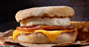 Classic Ham and Egg Breakfast Sandwich with Cheese on a Toasted English Muffin with Hash Brown Patti...