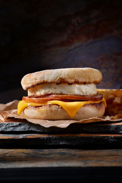 Classic Ham and Egg Breakfast Sandwich with Cheese on a Toasted English Muffin with Hash Brown Patti...