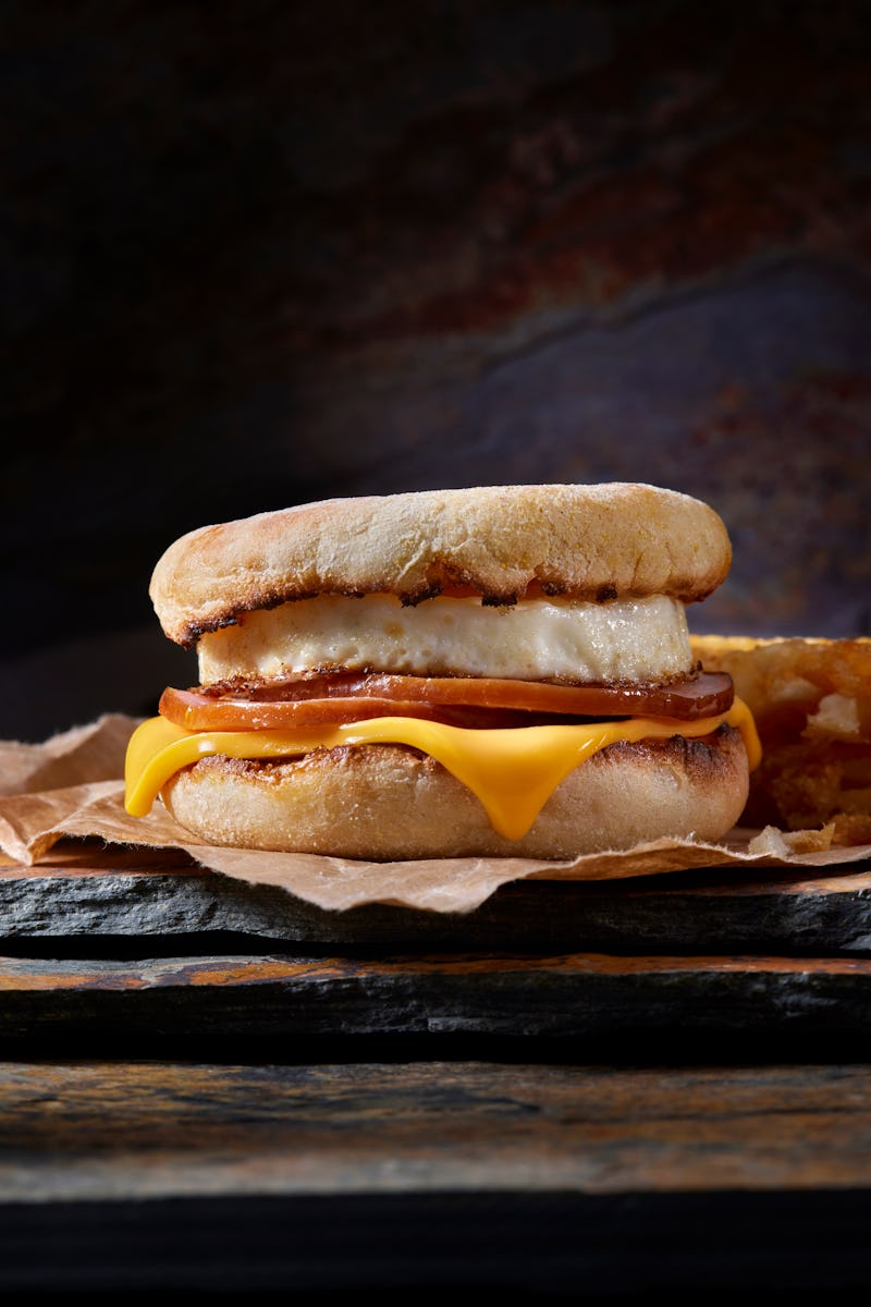 Classic Ham and Egg Breakfast Sandwich with Cheese on a Toasted English Muffin with Hash Brown Patti...