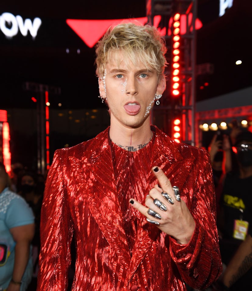 Machine Gun Kelly wears a red suit and black nails to the 2021 MTV Video Music Awards.