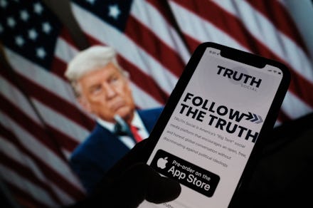 TOPSHOT - This illustration photo shows a person checking the app store on a smartphone for "Truth S...