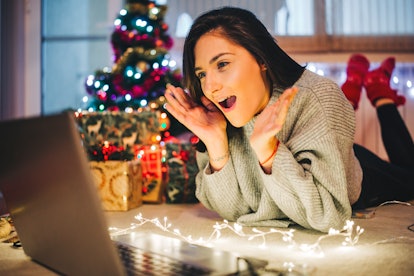 A young lady playing charades at a virtual holiday party 