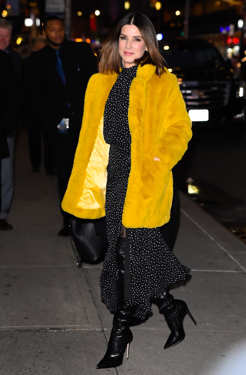 Sandra Bullock wearing a yellow faux fur jacket. 