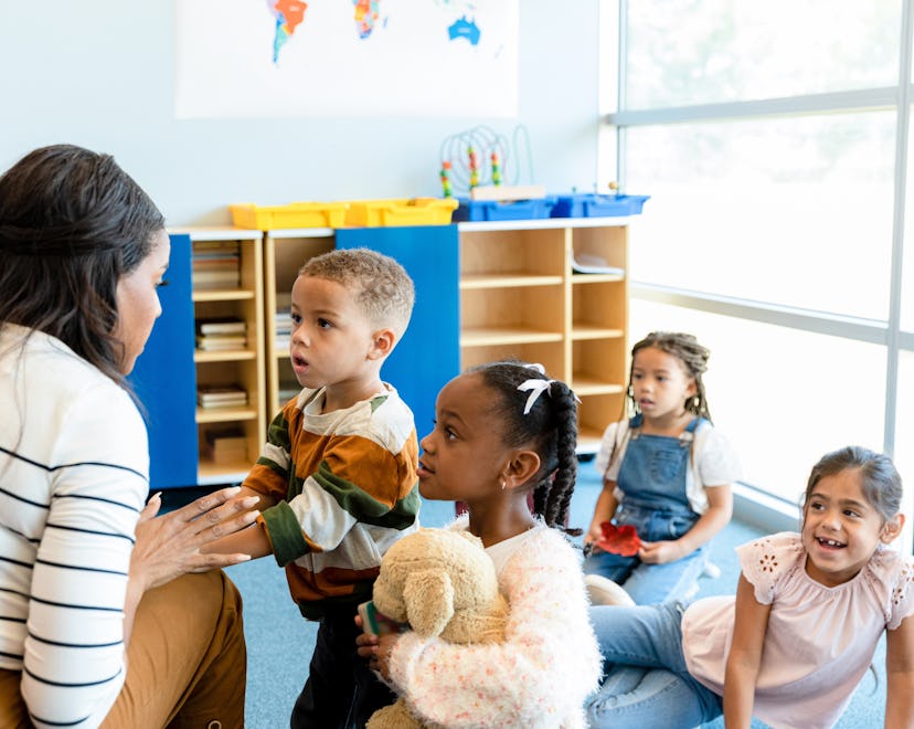 what to tip day care teachers like this woman giving young children one-on-one instructions.