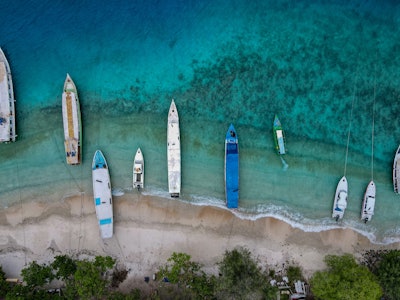 This aerial picture taken on November 22, 2021 shows boats anchored along an empty beach on Gili Tra...