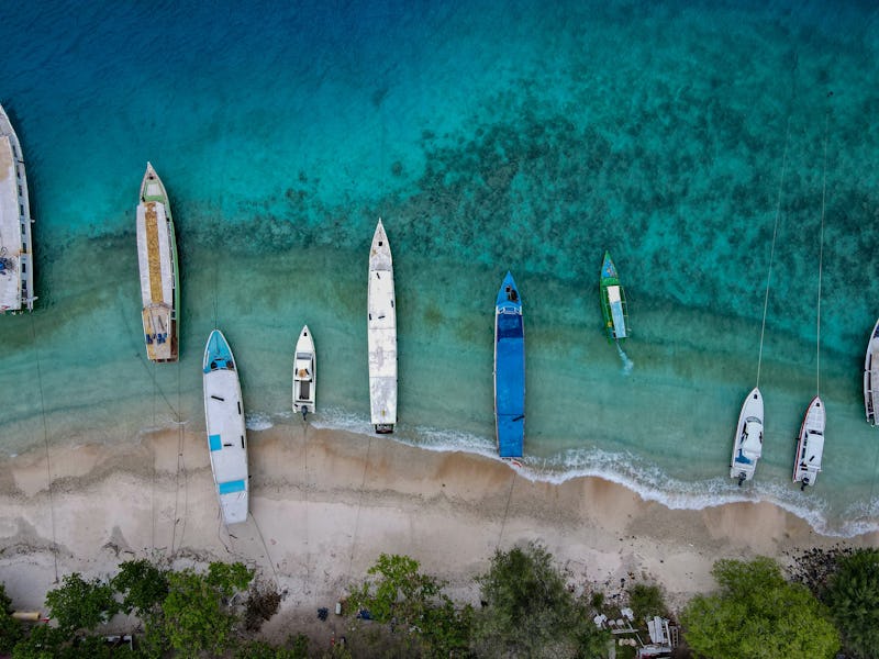 This aerial picture taken on November 22, 2021 shows boats anchored along an empty beach on Gili Tra...