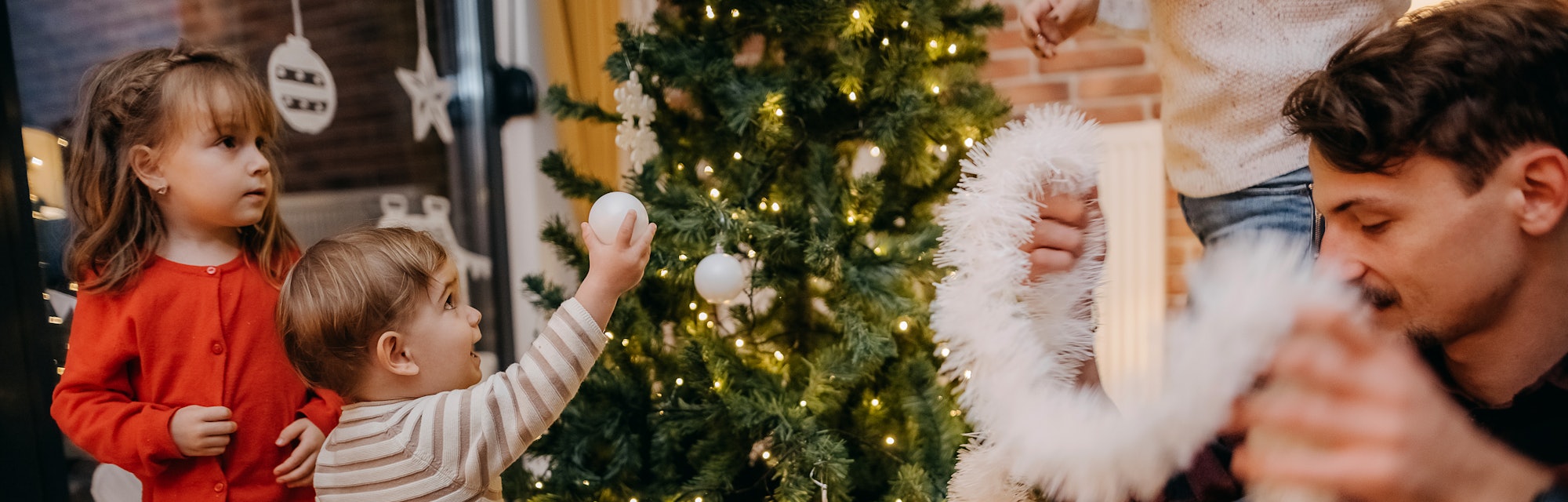 Family decorates the Christmas tree together and decorates it for the Christmas and New Year holiday...