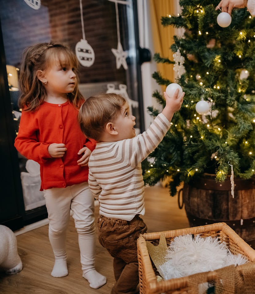 Family decorates the Christmas tree together and decorates it for the Christmas and New Year holiday...