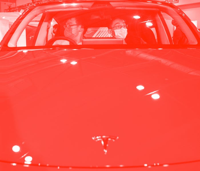 HONG KONG, CHINA - 2021/12/05: Visitors sit and test an American electric company car Tesla Motors c...