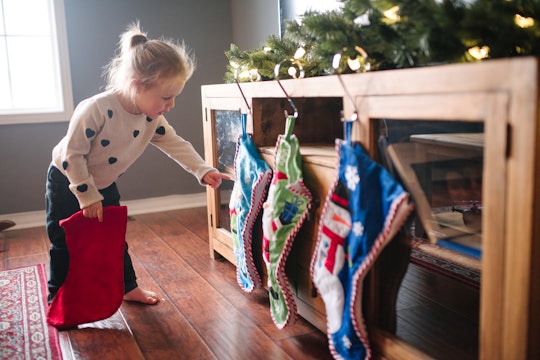 little girl looking at christmas stockings