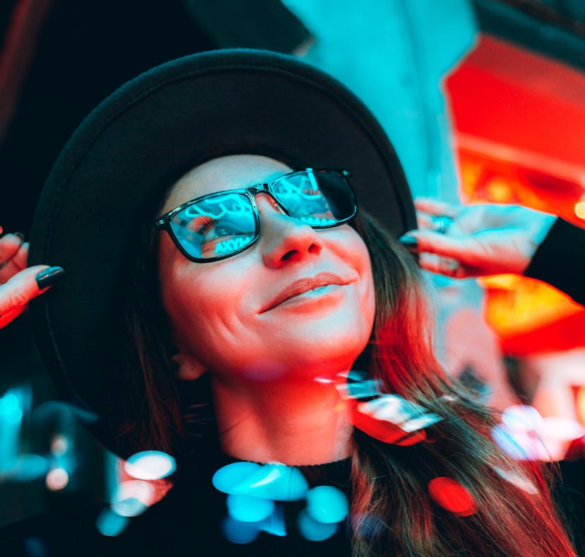 Young woman basking in bright city lights, thinking about how the January 2022 new moon in Capricorn...