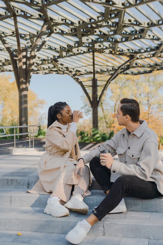 A couple having coffee while sitting on the stairs