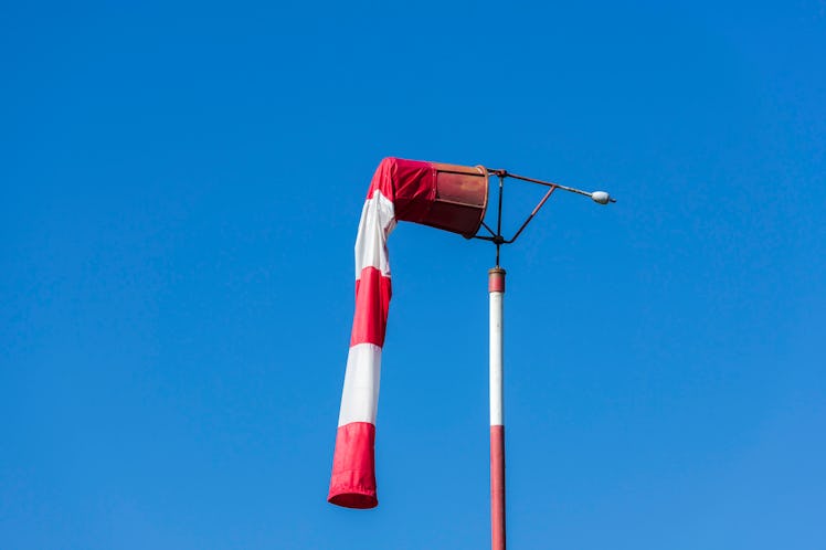 A wind sock in red an white hanging from the top section element