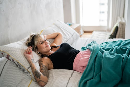 Woman sleeping on the bed at home. Here's your daily horoscope for December 10, 2021.