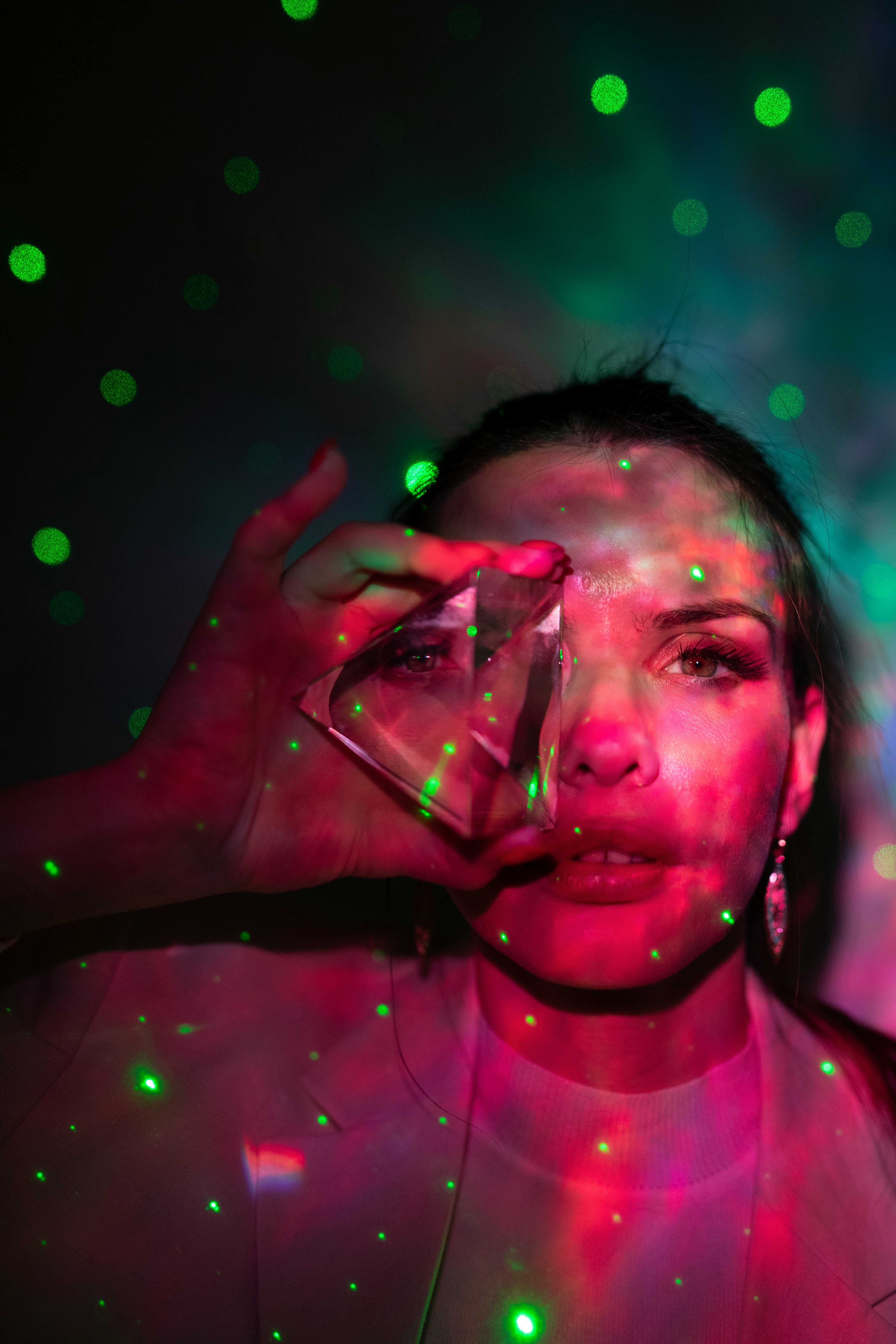 young woman holds a sphere up to her eye as she reflects on the best crystal for her zodiac sign
