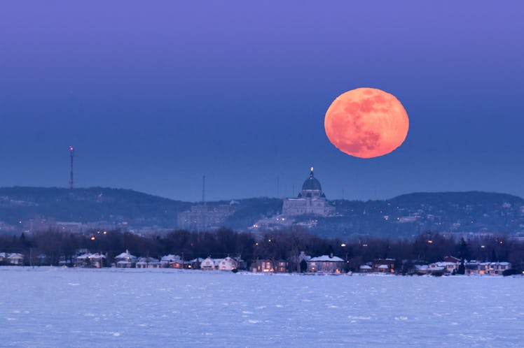 Supermoon rising over Montreal skyline in winter