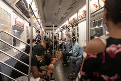 NEW YORK, NEW YORK - JULY 02: The view of people wearing masks inside a busy subway car as the city ...