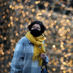 MANCHESTER, UNITED KINGDOM - DECEMBER 08: A woman wears a Covid-19 face mask as she walks past Chris...