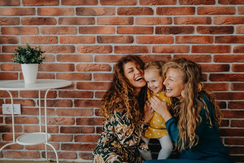 Married couple with their little girl smiling and laughing.