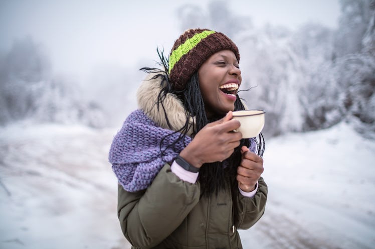 A happy woman laughs and thinks of snow quotes.