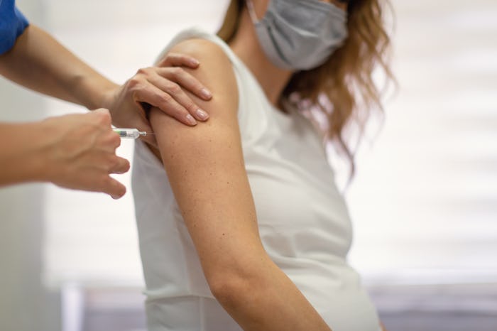 A pregnant woman receives a shot.