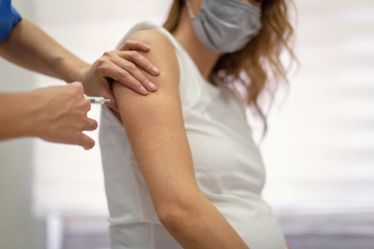 A pregnant woman receives a shot. 