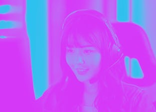 Woman wearing headphones and sitting at a computer.