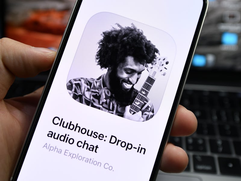 The main brand image of Clubhouse is seen in black and house. It is a man laughing while holding a g...