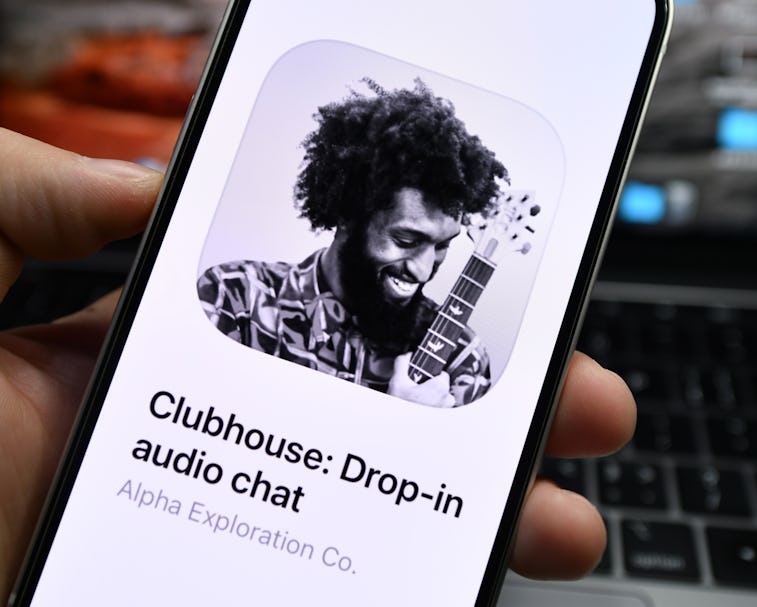 The main brand image of Clubhouse is seen in black and house. It is a man laughing while holding a g...