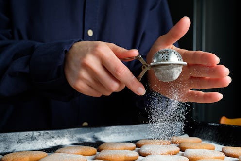 A person sifts sugar over cookies. Baking with Tourette Syndrome TikTok videos raise awareness about...