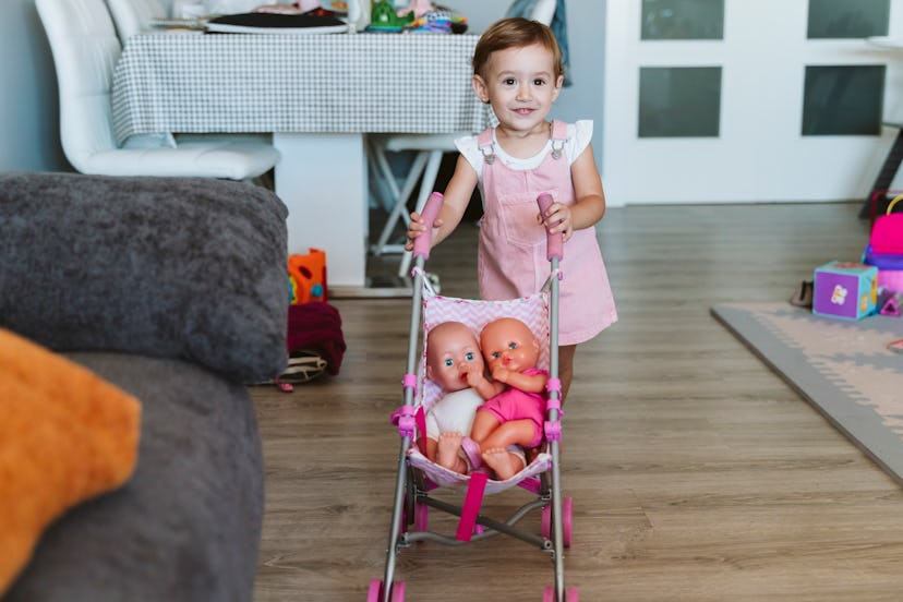 toddler pushing baby dolls in stroller