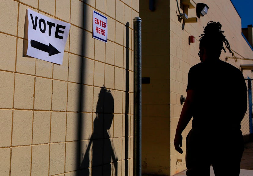 woman walking into polls to vote