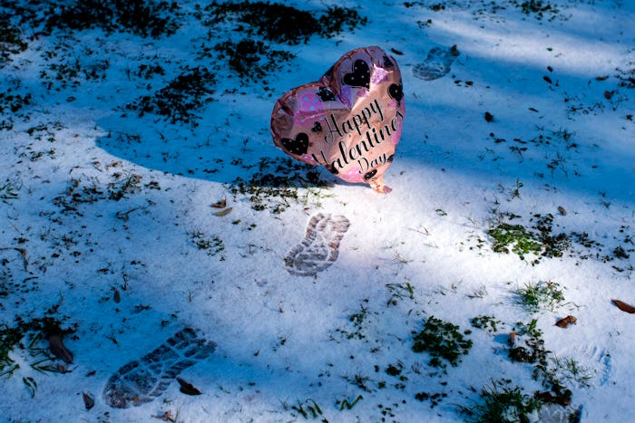 A deflating Valentine's Day balloon rests in the snow in Texas during a severe winter storm that has...