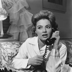 A woman with a shocked expression on a corded phone. The LOLA cup text hotline will answer questions...