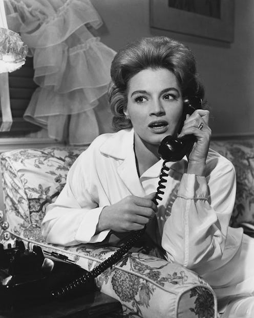 A woman with a shocked expression on a corded phone. The LOLA cup text hotline will answer questions...