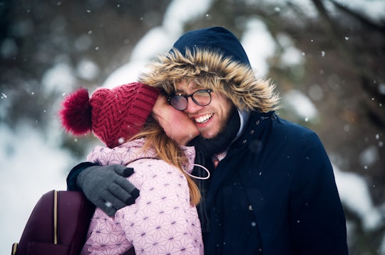 woman giving man a kiss in winter on hike