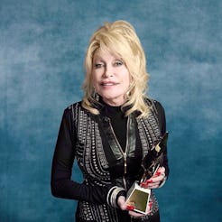 Dolly Parton holding Billboard's first-ever Hitmaker Award