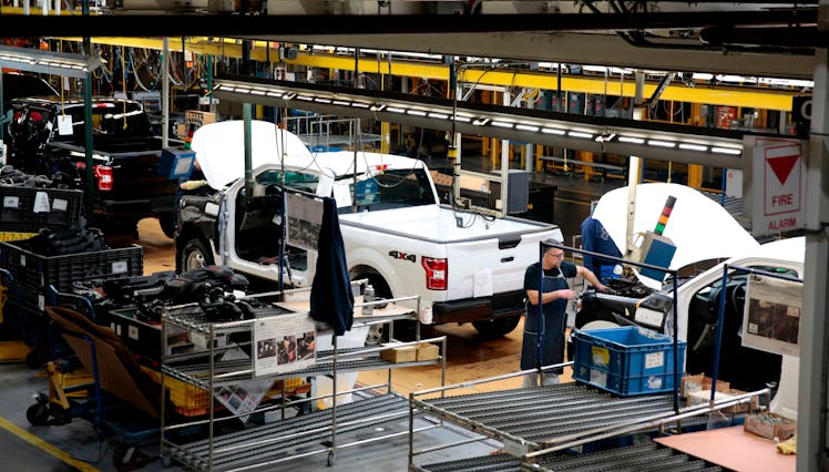 A picture of a white Ford truck being built on a construction line. 