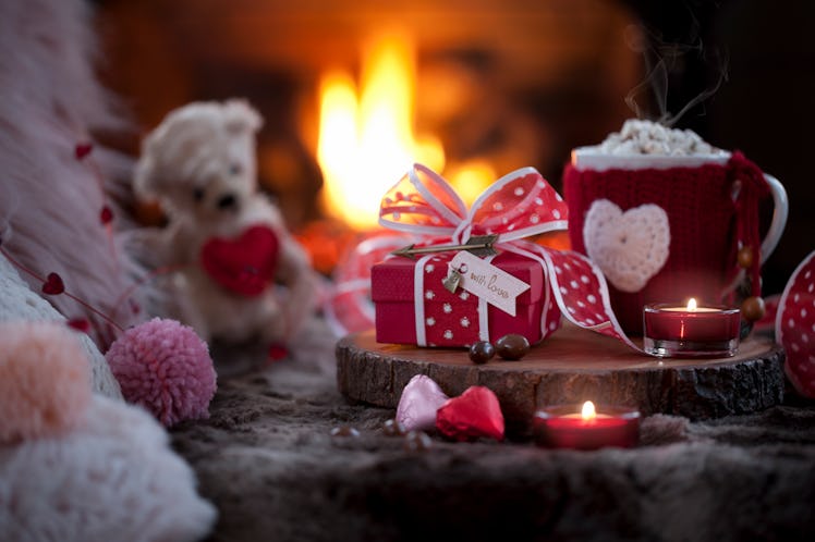 A Valentine's Day spread of hot cocoa bombs is placed next to a fireplace. 
