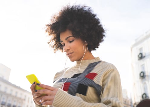 woman, phone, earbuds 