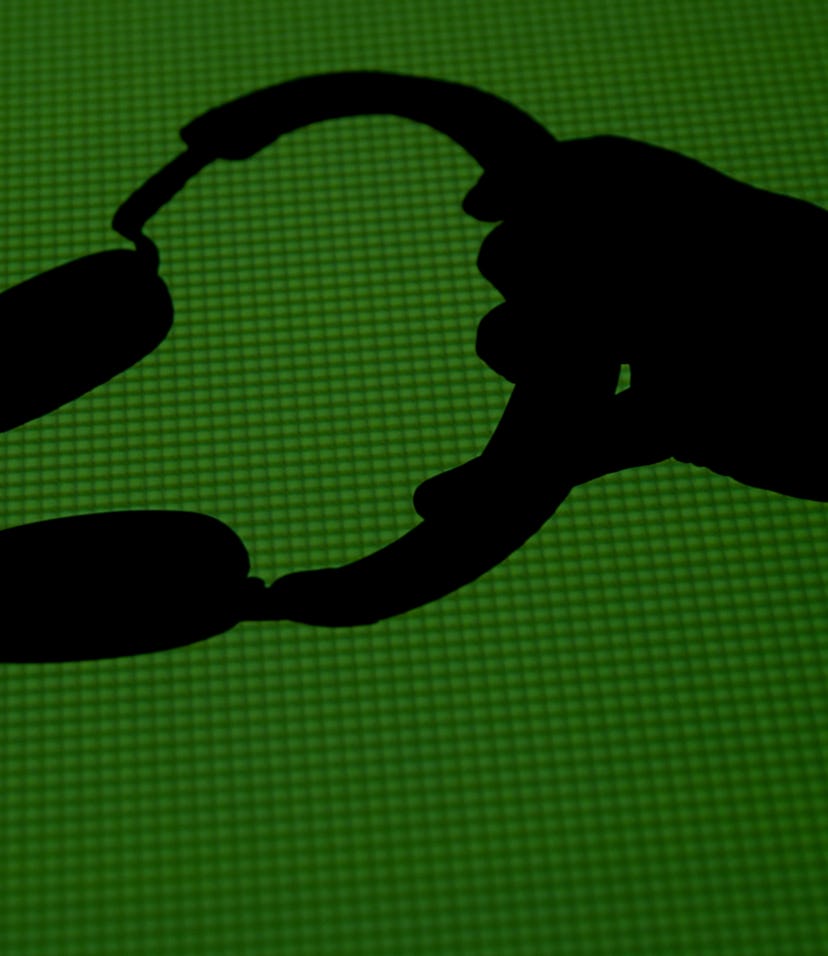 Silhouette of a hand holding a pair of headphones.