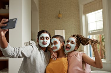 A group of young women take a selfie while doing facials at home during spring break.