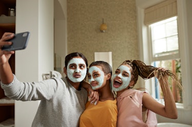 A group of young women take a selfie while doing facials at home during spring break.