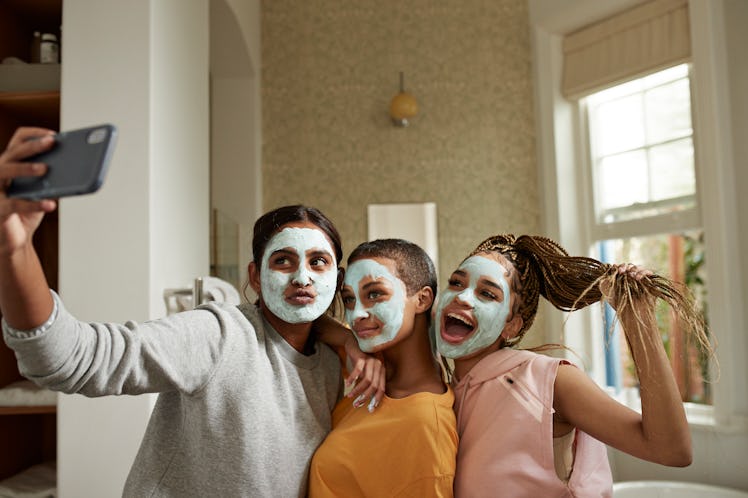 A group of young women take a selfie while doing facials at home during spring break.