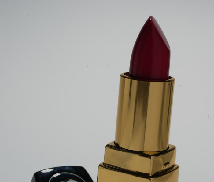 A lipstick by Chanel is seen on the screen. The color of the lipstick is deep red. The container is ...