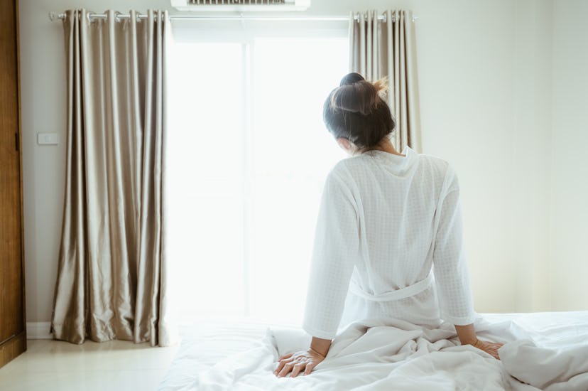 woman sitting on edge of bed